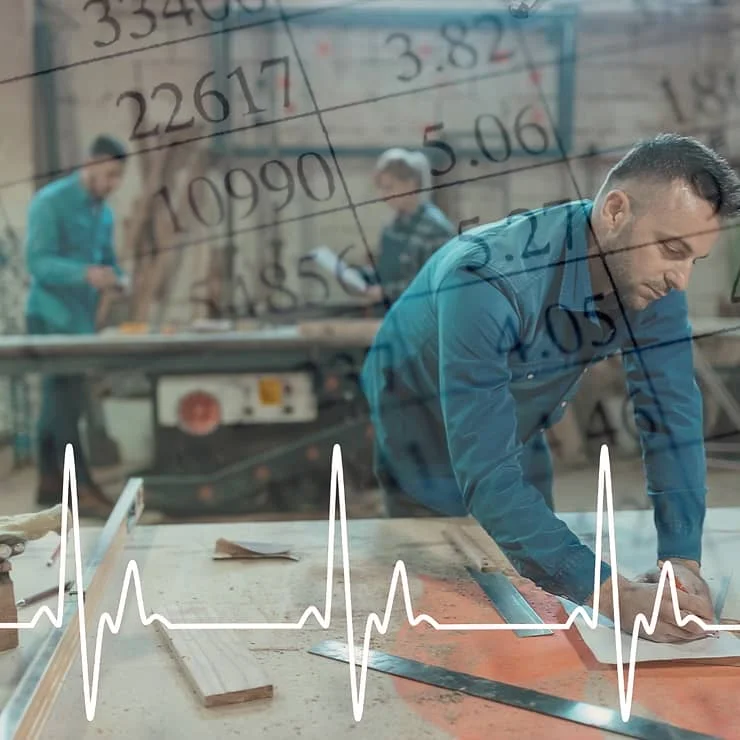 A man in a blue shirt focusing on cutting a piece of wood in a workshop, with other workers and numerical data overlayed, suggesting productivity metrics.