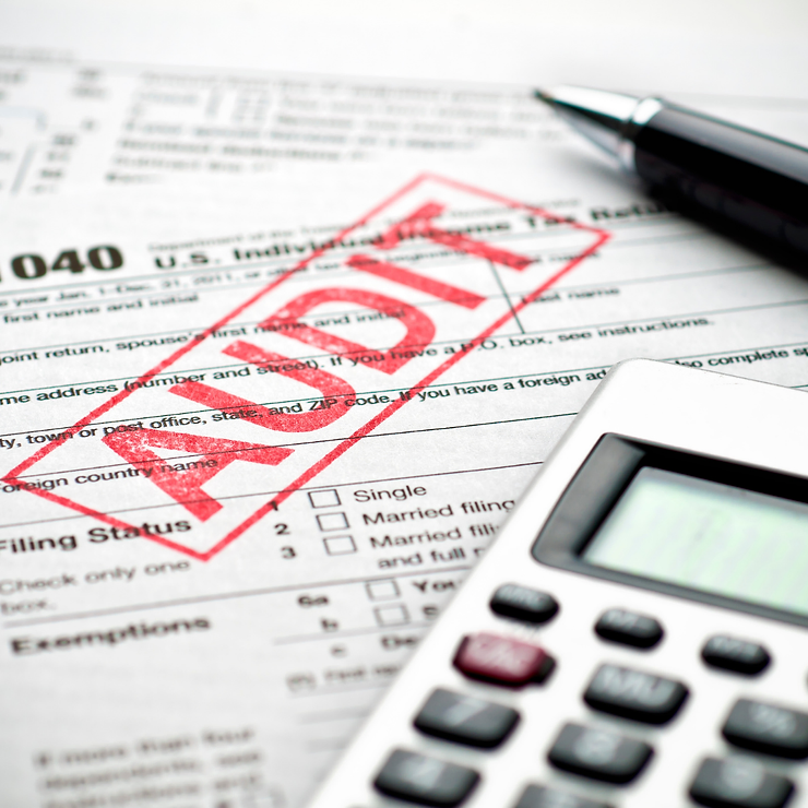 U.s. tax form 1040 with a red "void" stamp, alongside a pen and calculator, focusing on financial document accuracy.