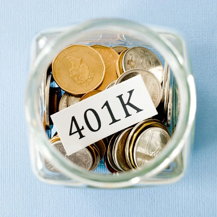 A glass jar filled with various coins and a tag labeled "401k" on a blue background.