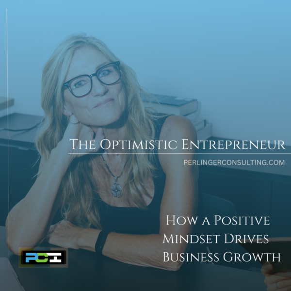 Small Business Owner sitting at her desk smiling. The title of the article is The Optimistic Entrepreneur.