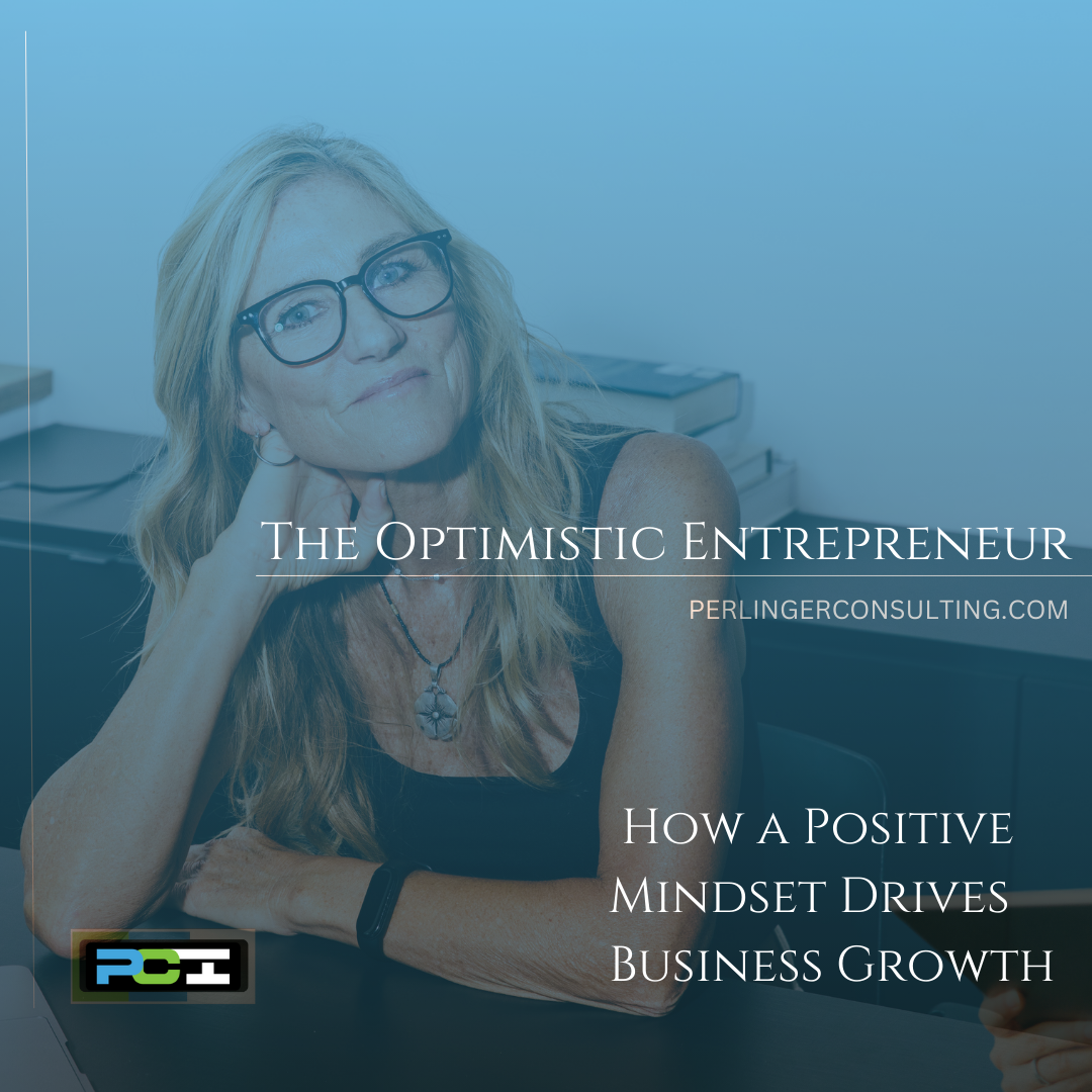 Small Business Owner sitting at her desk smiling. The title of the article is The Optimistic Entrepreneur.